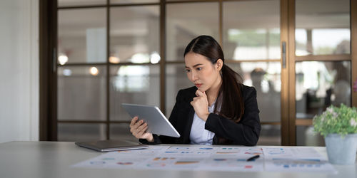 Young woman using laptop while sitting on table