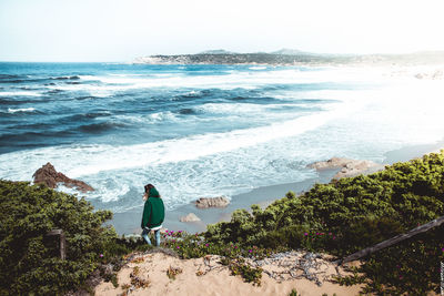 Woman standing on beach against clear sky