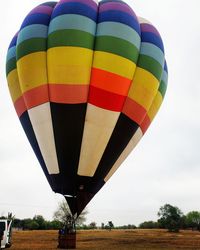 Multi colored hot air balloons on field against sky