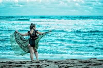 Woman on beach against sky