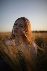 Portrait of beautiful woman on field against sky