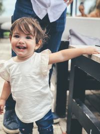 Smiling girl standing by table