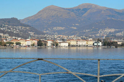 Scenic view of town by sea against sky