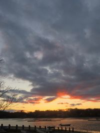 Scenic view of sea against dramatic sky during sunset