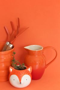 Close-up of coffee cup on table against orange background