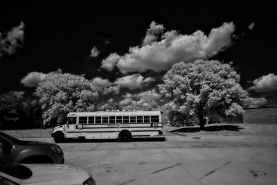 Car on road by trees against sky