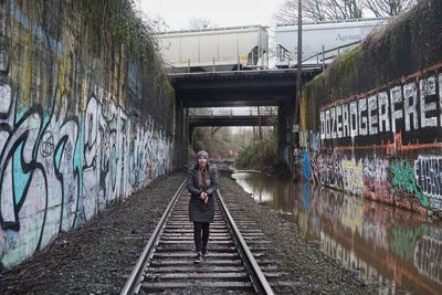 Rear view of man standing on railroad track