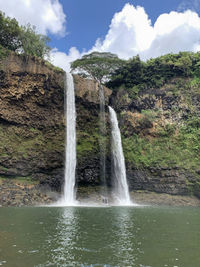 Scenic view of waterfall against sky