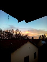 Houses against sky during sunset