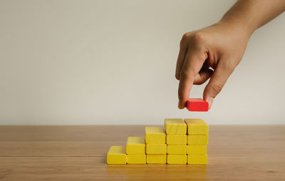 Midsection of person holding toy on table