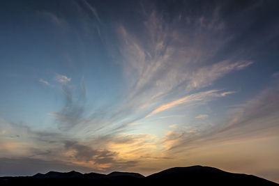 Low angle view of silhouette mountains against sky at sunset