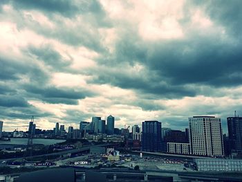 View of cityscape against cloudy sky