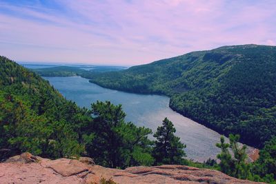 Scenic view of river by mountains against sky