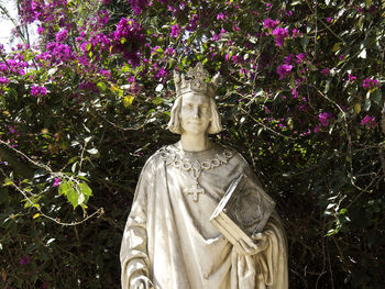 Statue of buddha against plants and trees