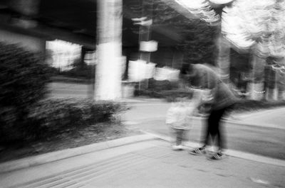 Blurred motion of people walking on street in city