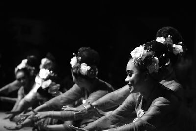 People sitting against black background