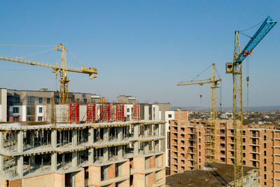 Construction site by buildings against sky