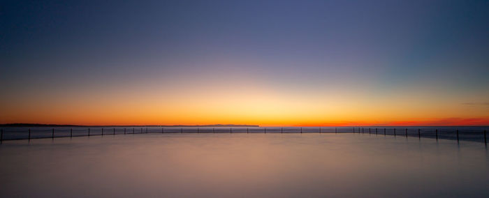 Scenic view of sea against clear sky during sunset