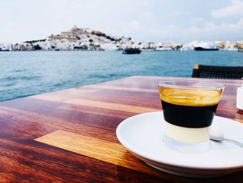 Coffee cup on table by sea