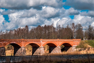 Arch bridge over river against sky