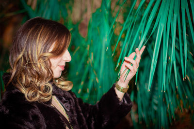 Portrait of young woman holding plants