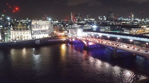 View of illuminated bridge over river at night