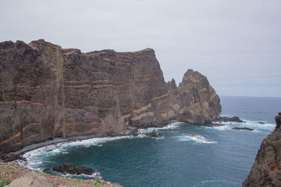 Rock formations by sea against sky