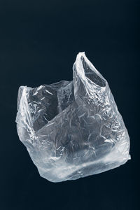 Close-up of ice plastic bag against black background