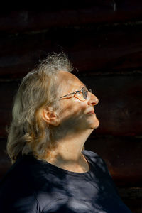 Portrait of elderly woman in glasses close-up on natural background. profile of man with sunset 