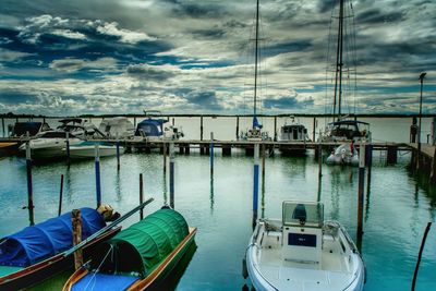 Boats in sea against cloudy sky