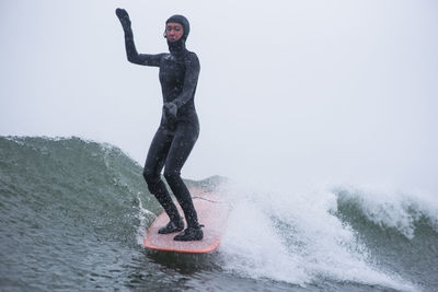 Full length of young man in sea during winter