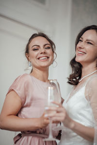 Bridesmaid and bride holding champagne flute