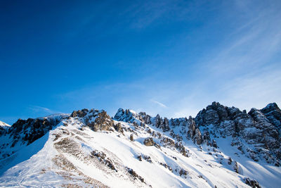 Scenic view of snowcapped mountains against blue sky