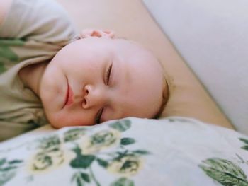 Close-up of baby boy sleeping on bed at home