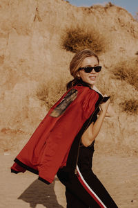 Portrait of young woman wearing sunglasses standing outdoors