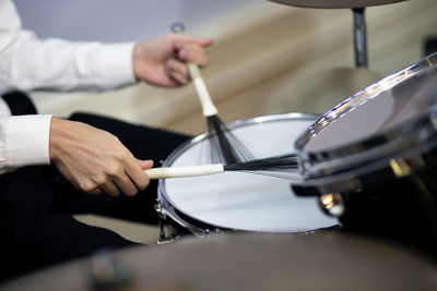 Midsection of man playing drum