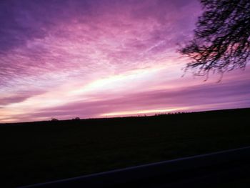 Silhouette landscape against dramatic sky during sunset