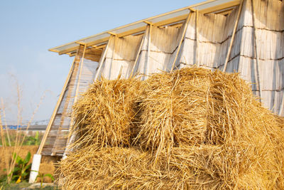 Low angle view of hay bales on field against sky