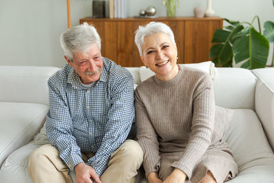 Portrait of senior man sitting on sofa at home