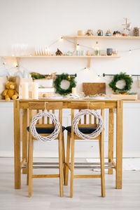 Wooden dining table with chairs decorated for christmas and new year in a bright scandinavian style