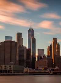 Skyscrapers in city against cloudy sky