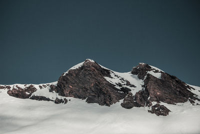 Scenic view of snowcapped mountains against clear sky