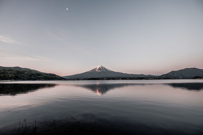 Scenic view of lake by mountain against sky