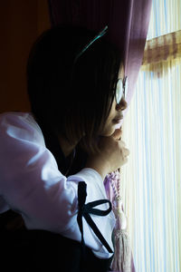 Close-up of girl looking through window