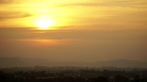 Scenic view of silhouette mountains against orange sky