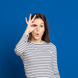 Portrait of a young woman against blue background