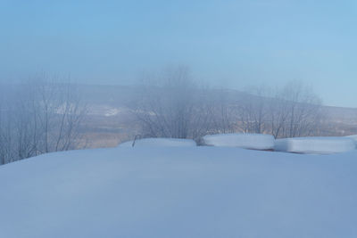 Snow covered landscape against clear sky