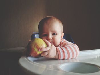 Portrait of boy with apple on table