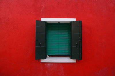 Close-up of window on red  wall