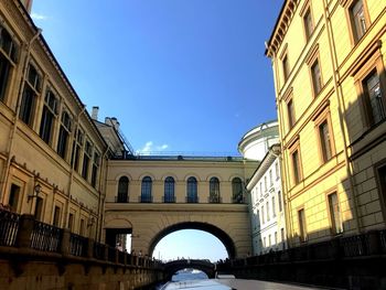 Low angle view of arch bridge against sky in city